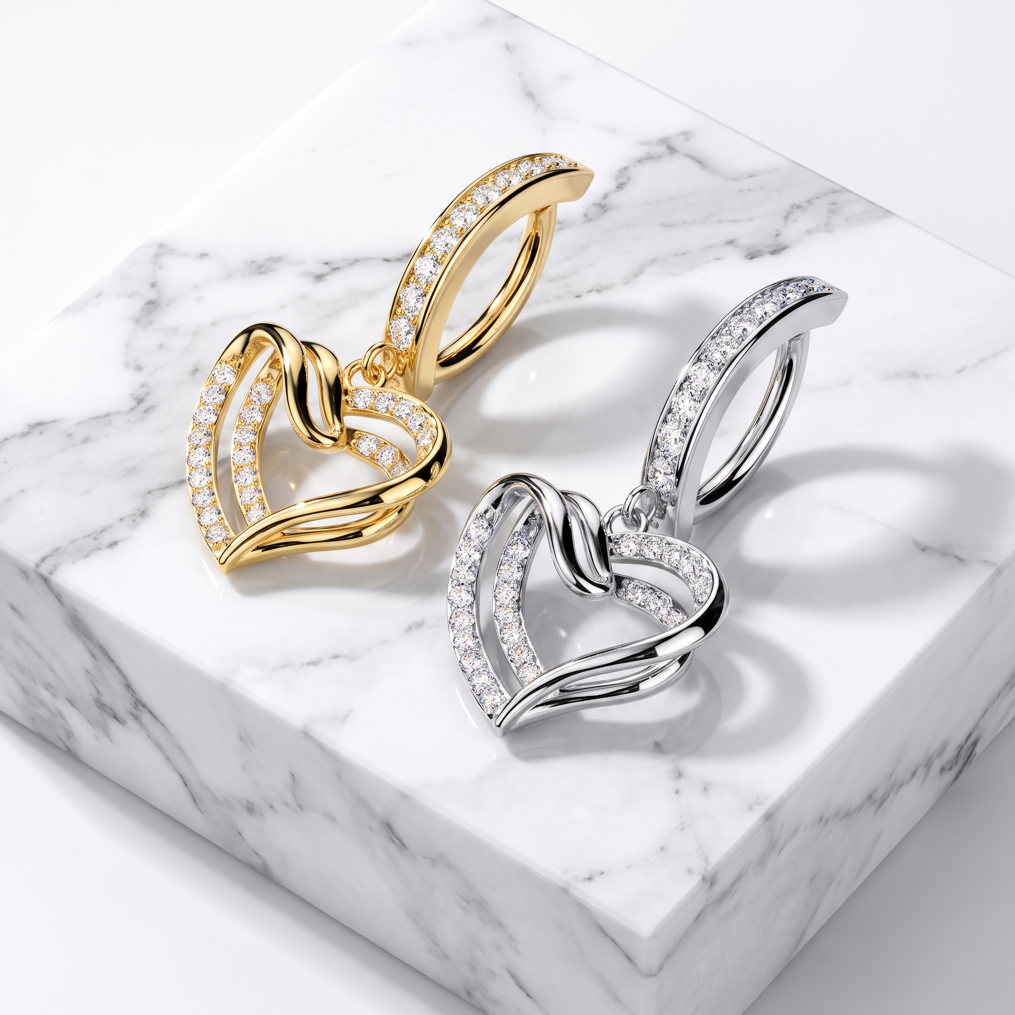 Two interlocking heart-shaped hoop earrings displayed on a white marble block. One earring is yellow gold with clear stones, and the other is silver with clear stones.