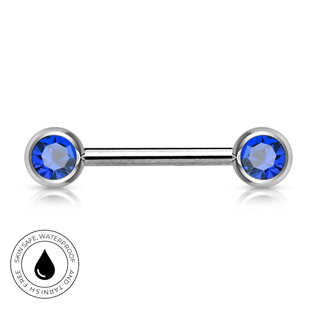A silver-toned labret piercing barbell with round blue faceted gemstones on both ends, shown on a white background with a circular 'Skincare Waterproof and Tarshal Free' badge in the lower-left corner.