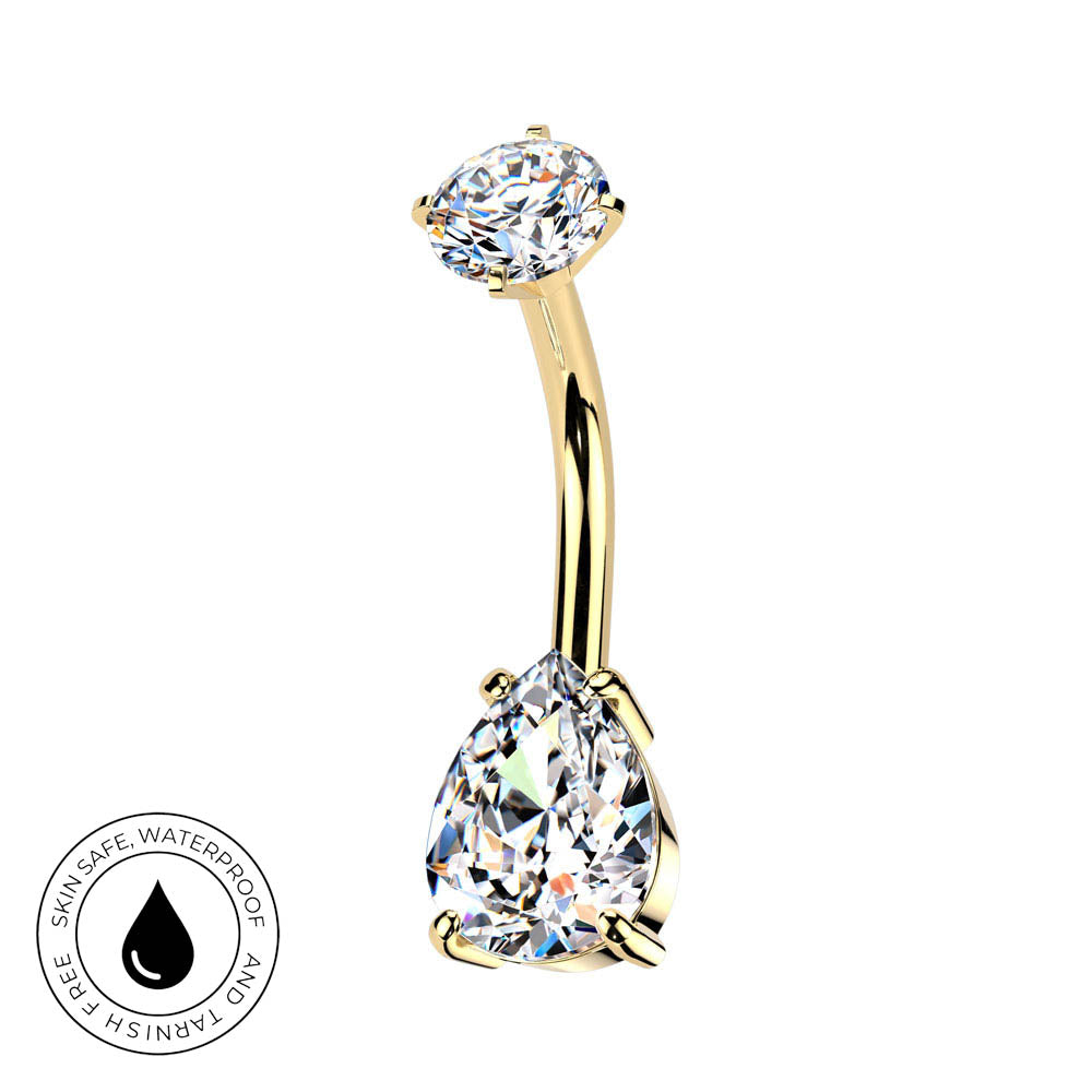 Gold curved barbell navel jewelry with a large pear-cut clear gemstone on the bottom and a smaller oval-cut clear gemstone on the top, shown on a white background with a circular skin-safe waterproof badge in the lower left.