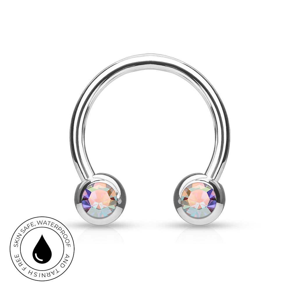 A silver-toned curved barbell piercing stud with two round iridescent gemstones, shown on a white background with a circular 'Skin Safe Waterproof and Tarnish Free' badge in the lower left.
