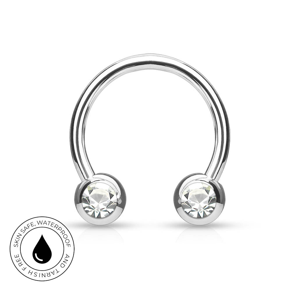 A silver-toned curved barbell piercing stud with two clear faceted gemstones in round bezel settings, shown on a white background with a circular 'skin-safe waterproof' badge in the lower-left corner.