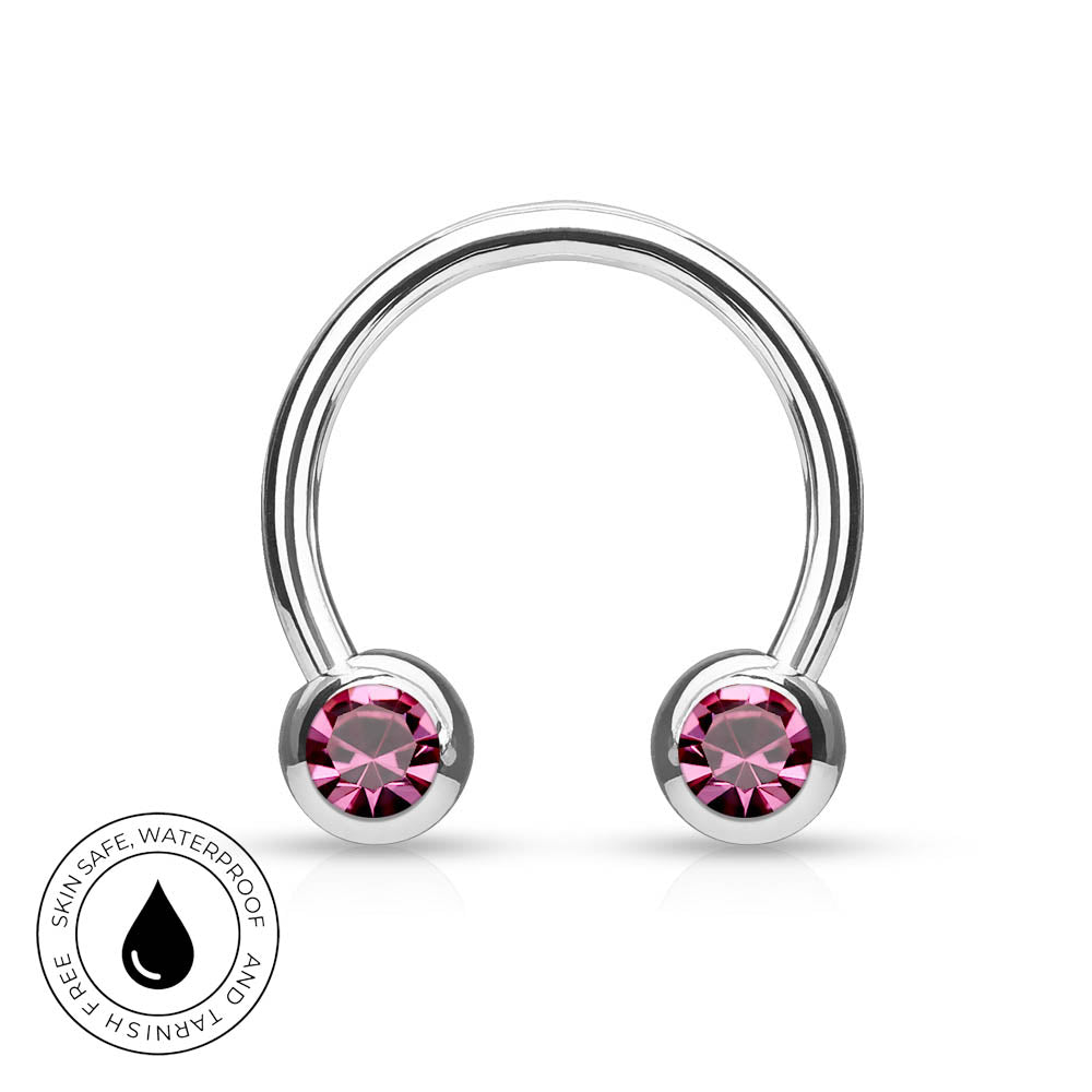 A silver-toned curved barbell piercing stud with two round pink gemstones, shown on a white background with a circular 'Skin Safe Waterproof' badge in the lower left corner.