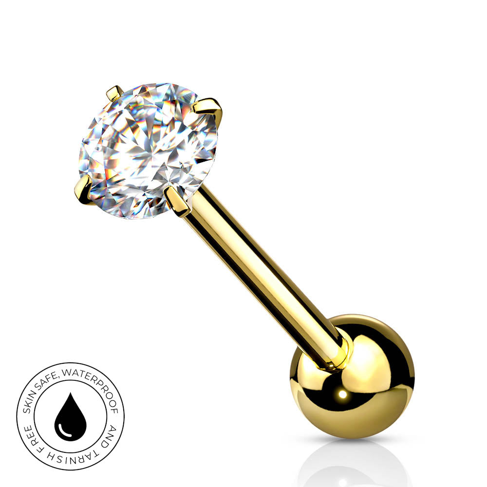 A gold-plated labret piercing barbell with a round-cut clear gemstone in a four-prong setting and a polished ball back, shown on a white background with a small circular 'skin-safe waterproof' badge in the lower left.