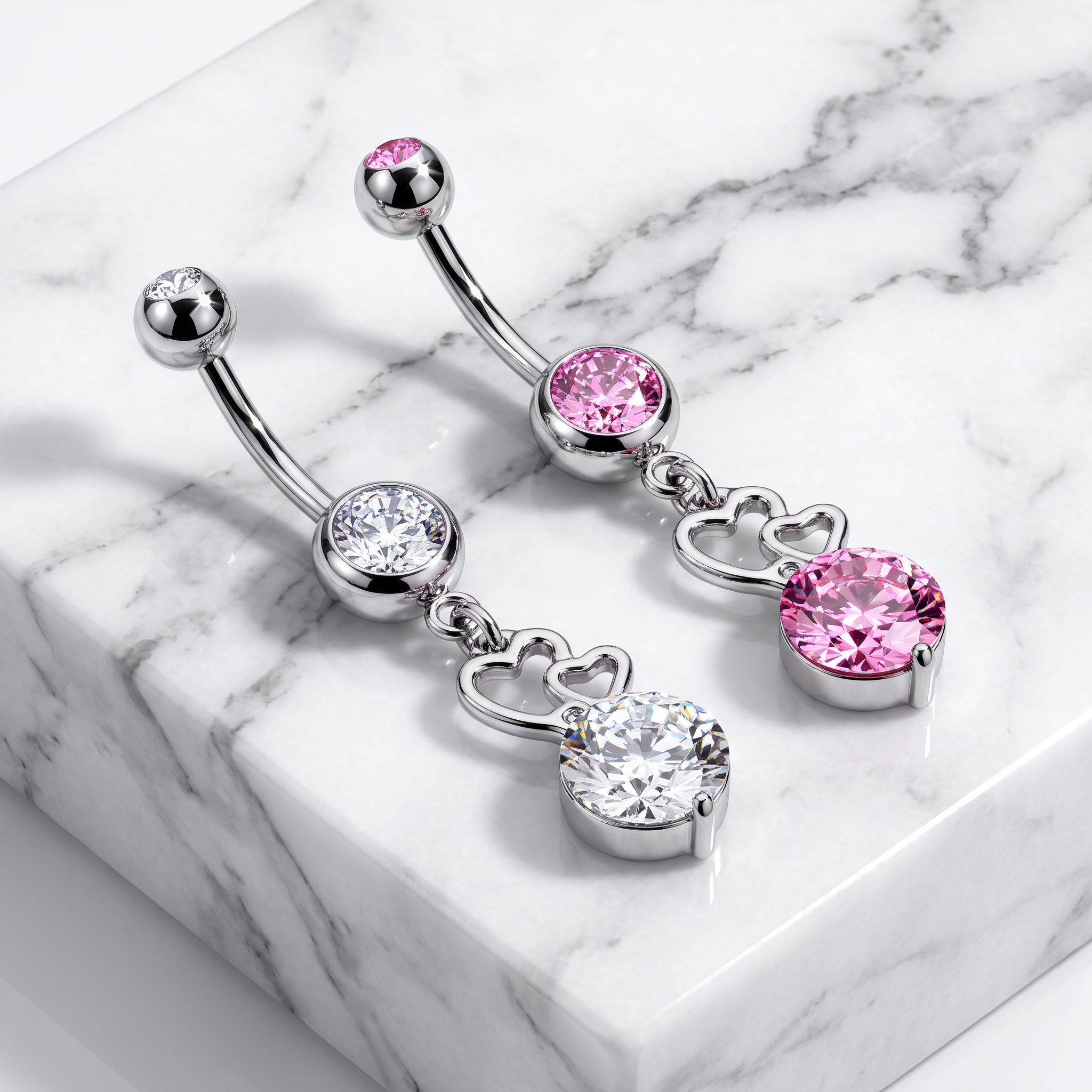 Silver-toned curved barbell belly button jewelry with pink and clear gemstones, displayed on a white marble block.