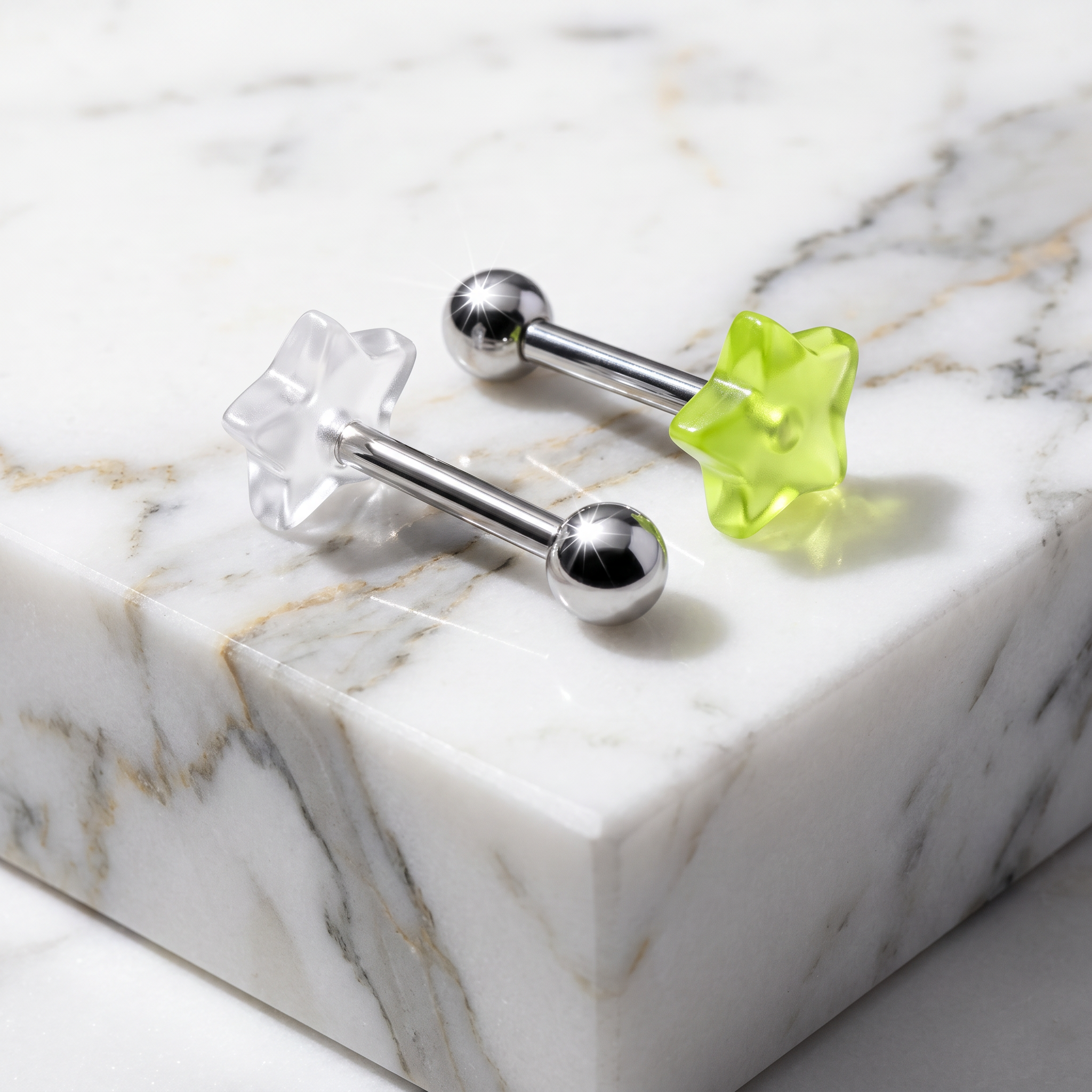 Two star-shaped labret earrings on a white marble block. One earring has a clear, transparent star-shaped back, and the other has a translucent lime green star-shaped back, both with polished silver-toned steel bars and ball end beads.