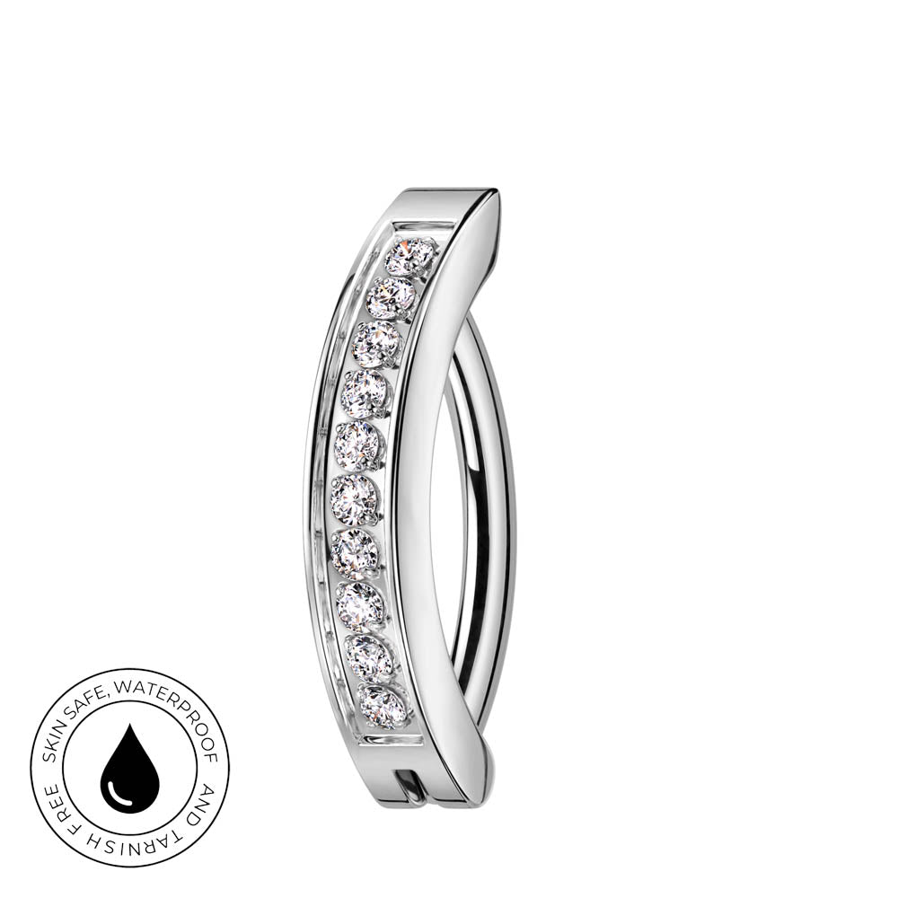 A curved silver-toned hoop ring with a channel of clear cubic zirconia stones on the front, shown on a plain white background with a circular 'skin-safe waterproof' badge in the lower-left corner.