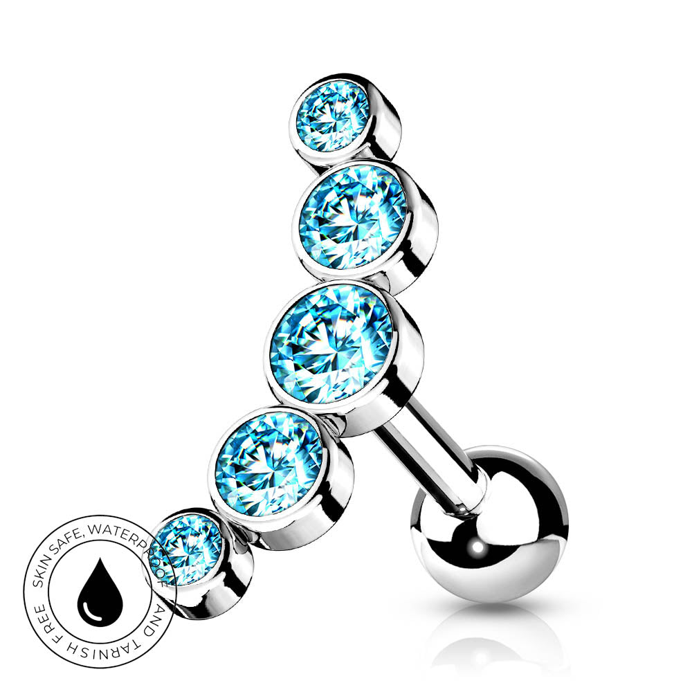 A silver-toned curved barbell belly button piercing with four stacked round light blue gemstones, shown on a white background with a small circular water-safe badge in the lower left.