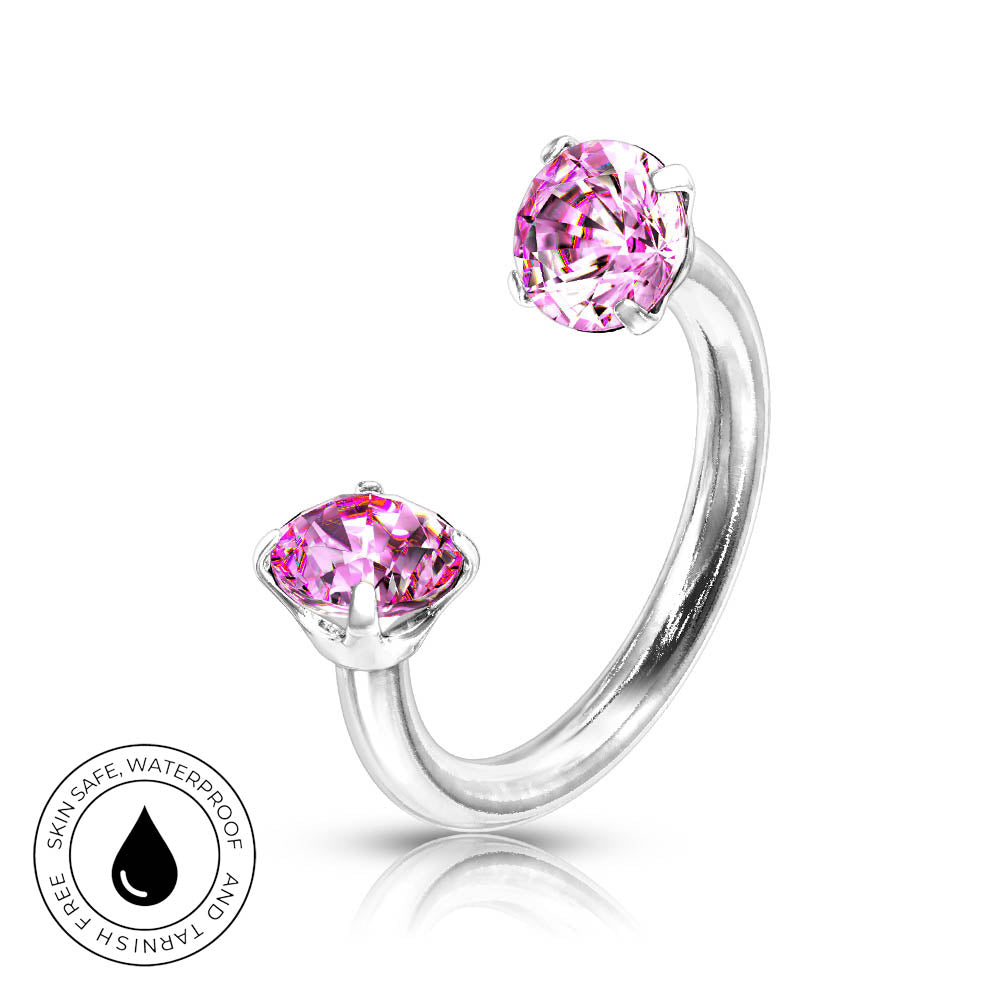A silver-toned open ring nose stud featuring two round-cut pink gemstones in prong settings, shown on a white background with a small circular skin-safe waterproof badge in the lower left.