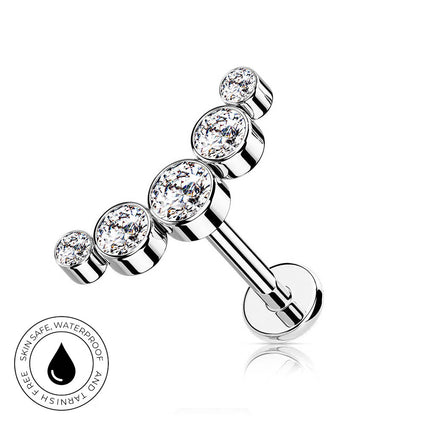 A silver-toned barbell-style body jewelry piece with four clear round gemstones, shown on a white background with a small circular skin-safe waterproof badge in the lower left.