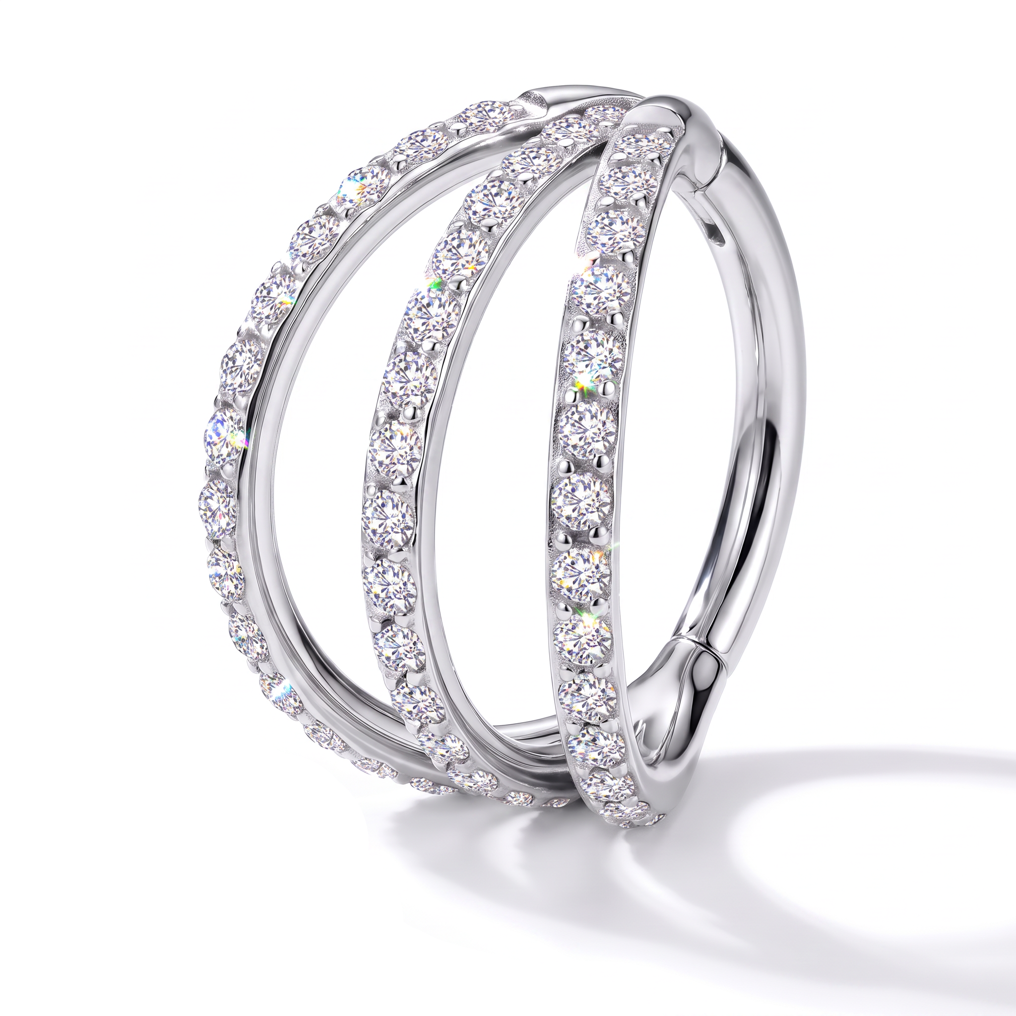 A silver-toned triple-band hoop ring set with clear round-cut gemstones, photographed on a clean white background with a soft shadow.
