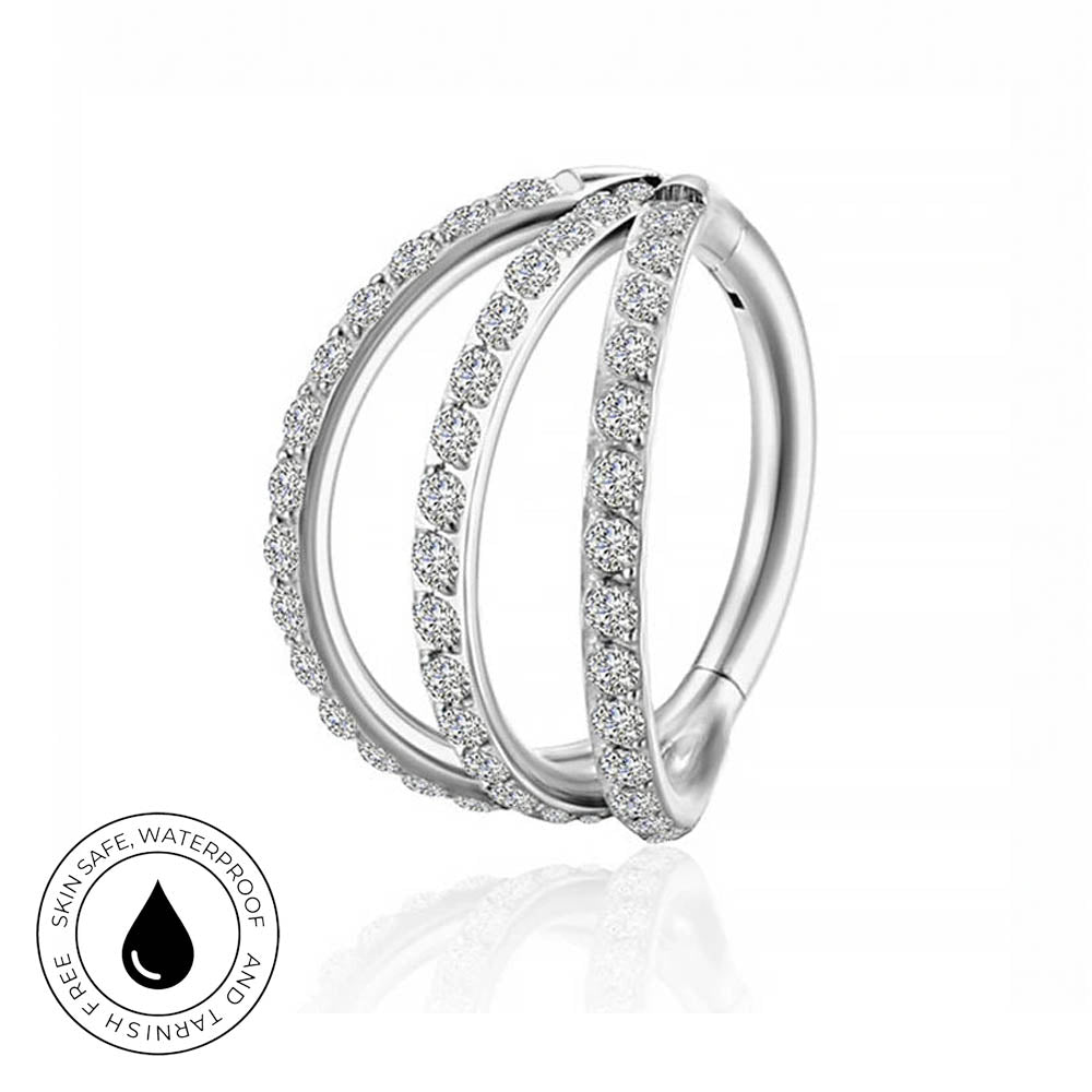 A silver-toned triple-band hoop piercing ring adorned with clear pavé-set gemstones, shown on a white background with a reflection below and a circular 'Skin Safe Waterproof' badge in the lower-left corner.
