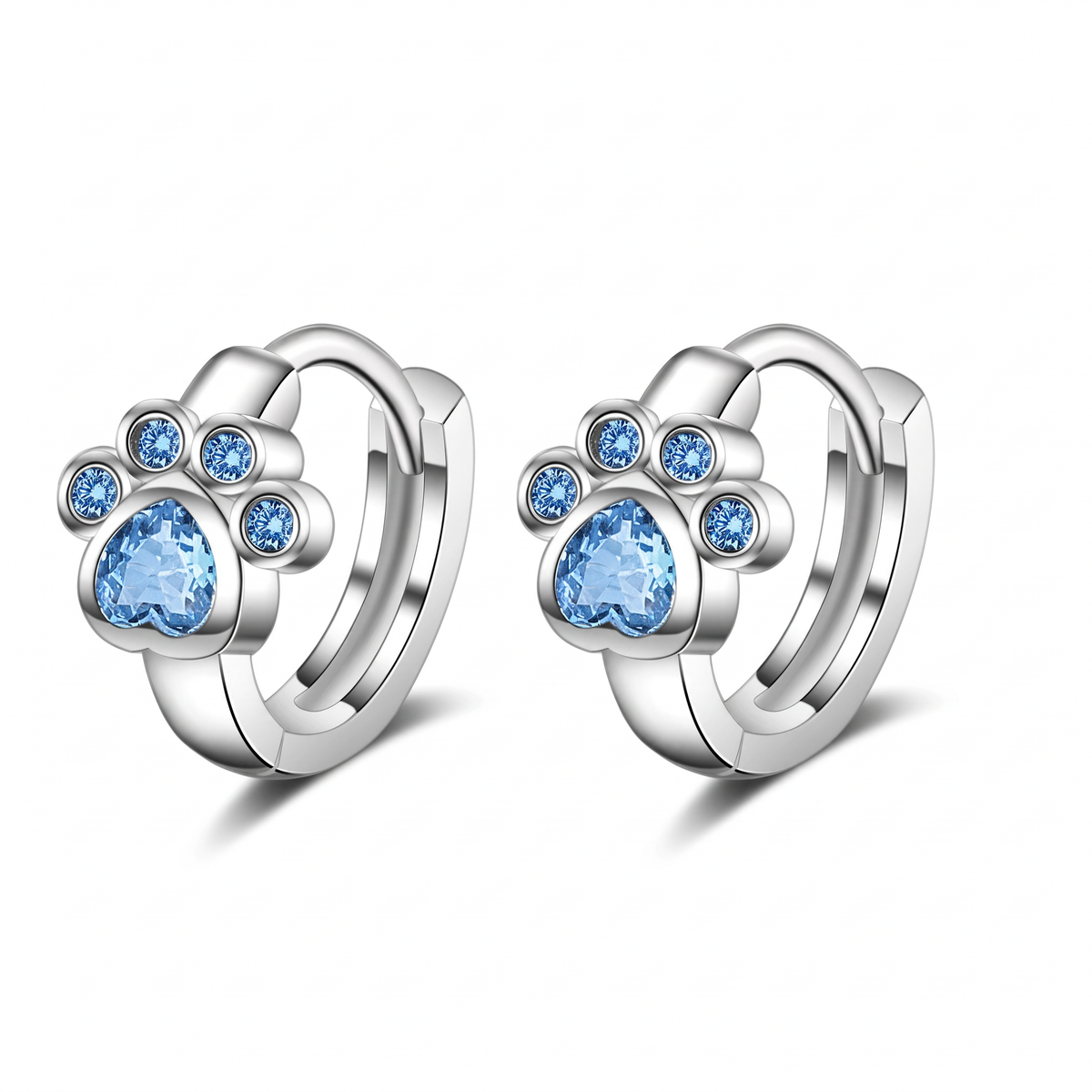 A pair of silver huggie hoop earrings featuring a paw print design with light blue heart-shaped and round gemstones, set against a plain white background.