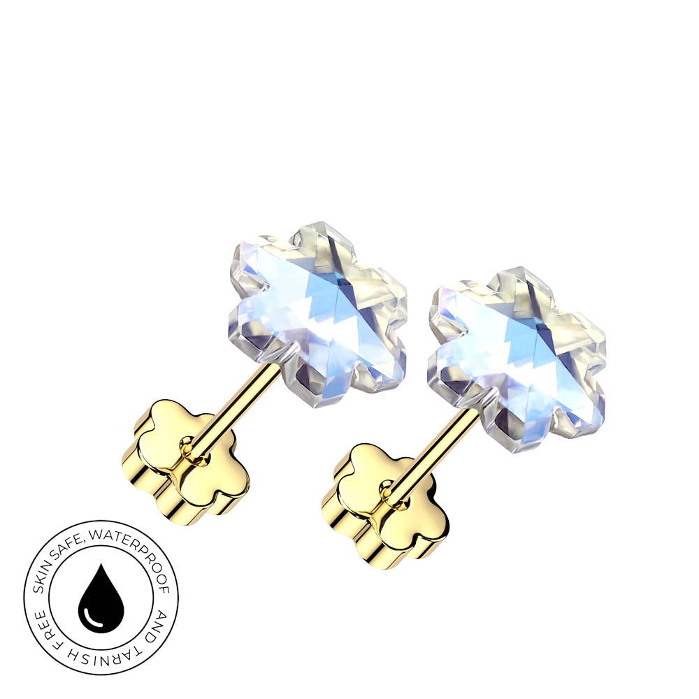 A pair of gold-plated flower-shaped stud earrings with clear faceted gemstones, shown on a plain white background. A circular badge in the lower-left corner highlights skin-safe, waterproof quality.