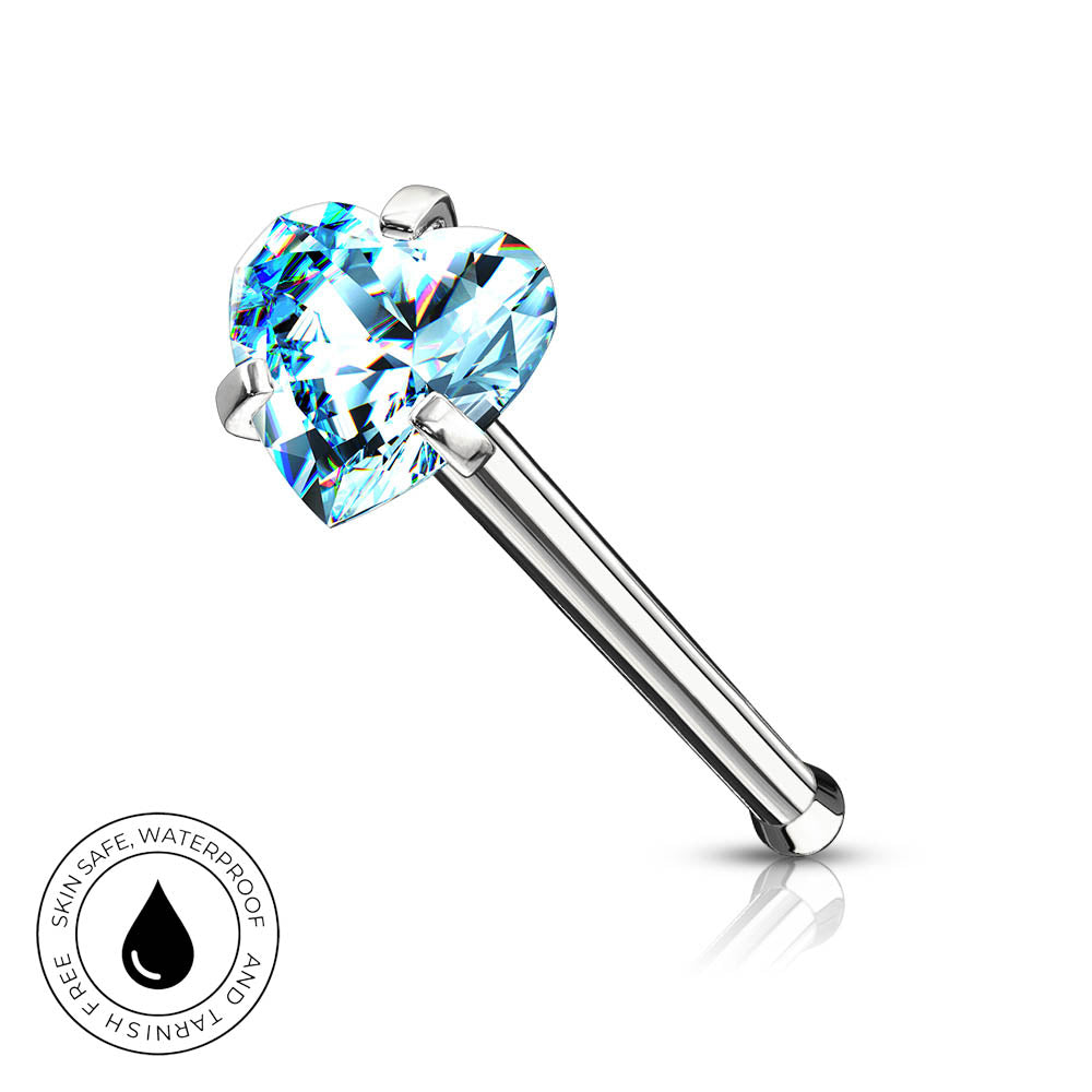 A silver-toned labret piercing barbell featuring a faceted, heart-shaped light blue gemstone, shown on a clean white background with a small circular 'SkinSafe Waterproof' badge in the lower-left corner.