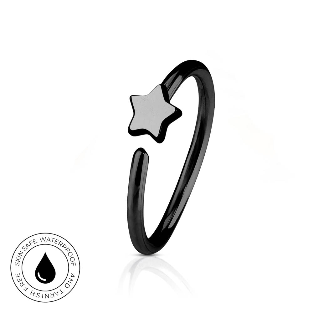 A black metal open-ended ring with a small five-pointed star charm, shown on a white background with a reflection and a circular skin-safe waterproof badge.