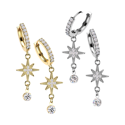 Four dangle hoop earrings shown on a plain white background: two in yellow gold and two in silver, each featuring a pavé-set hoop, a starburst charm, and a dangling round clear stone.
