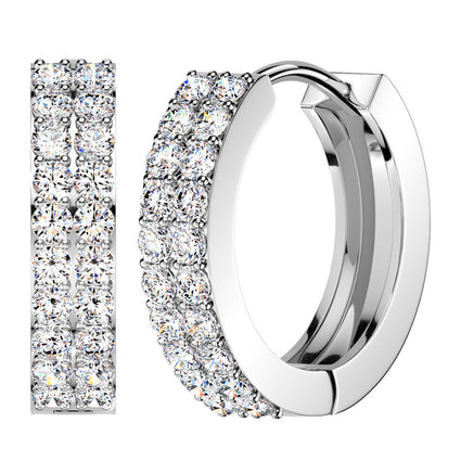 A pair of silver-toned huggie hoop earrings paved with round clear stones, shown on a plain white background with one earring viewed from the side and the other from the front.