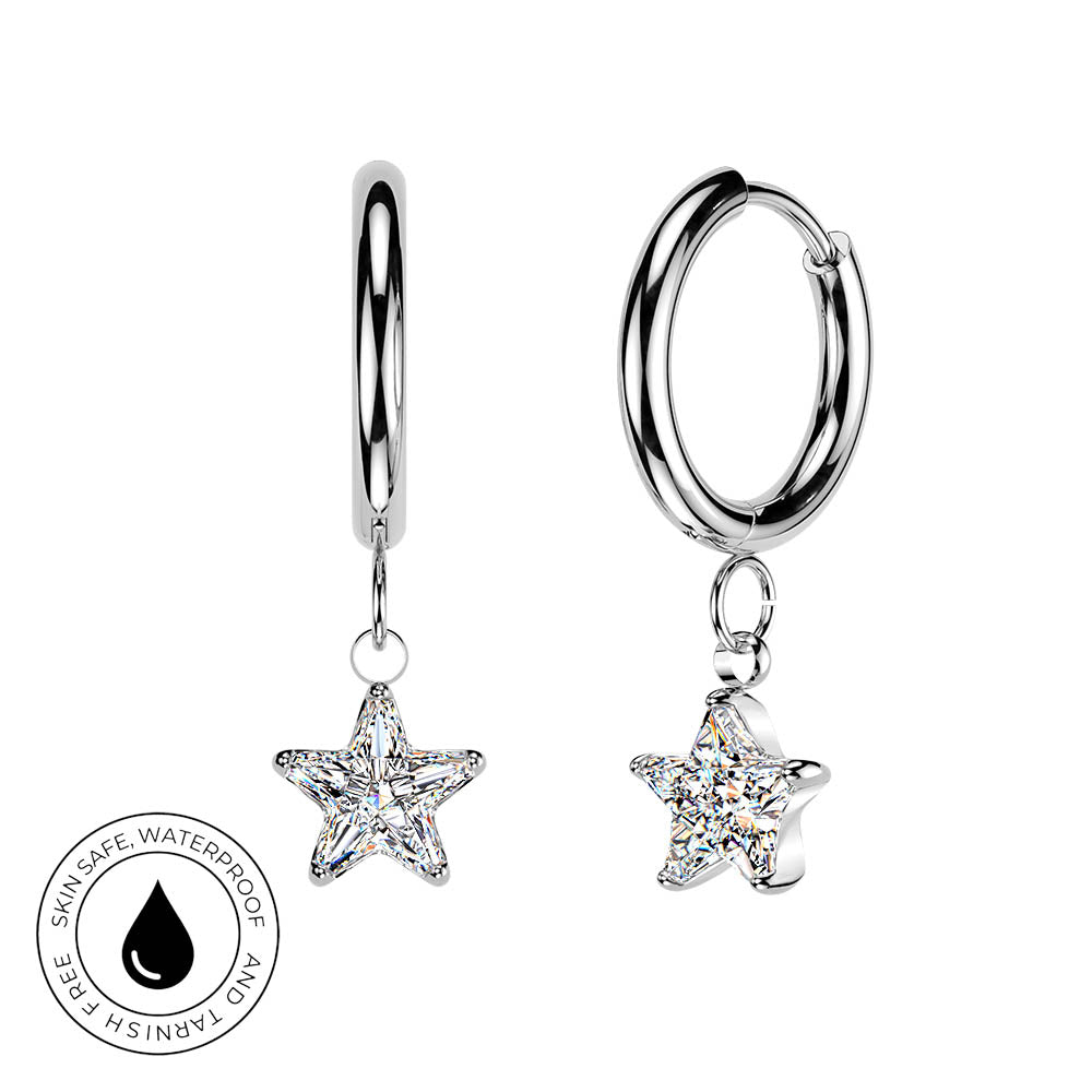 A pair of silver huggie hoop earrings with dangling star-shaped clear crystals, shown on a white background with a circular 'skin-safe waterproof' badge in the lower left.
