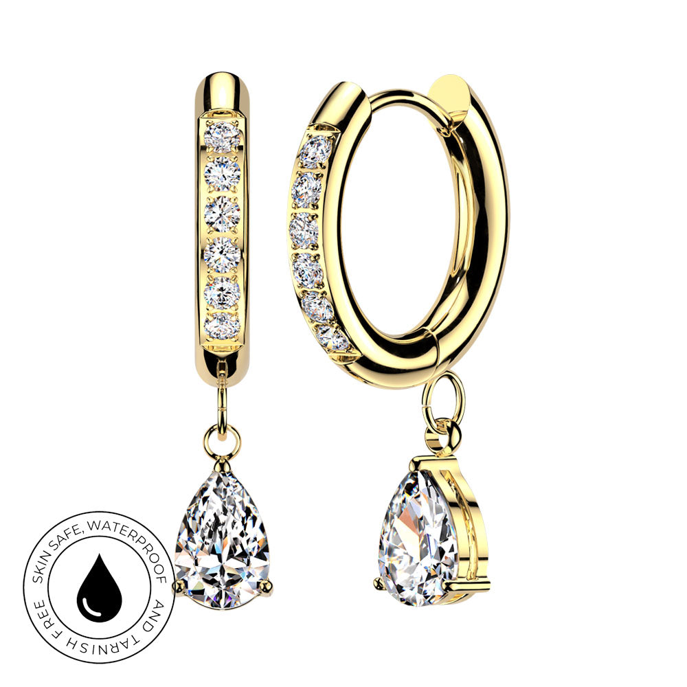 Gold huggie hoop earrings with clear pavé stones and a teardrop-shaped clear gemstone dangle, shown on a white background with a circular skin-safe waterproof badge.