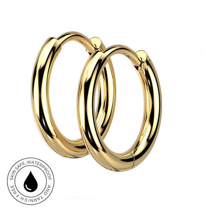 Two polished gold hoop earrings shown on a plain white background, with a circular inset badge at the lower left reading 'Skin Safe, Waterproof, and Tarnish Free' with a droplet icon.
