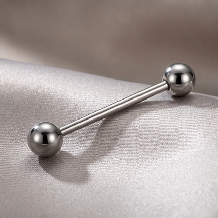 A silver stainless steel barbell piercing jewelry piece with two spherical ball ends, resting on a textured light gray fabric surface.