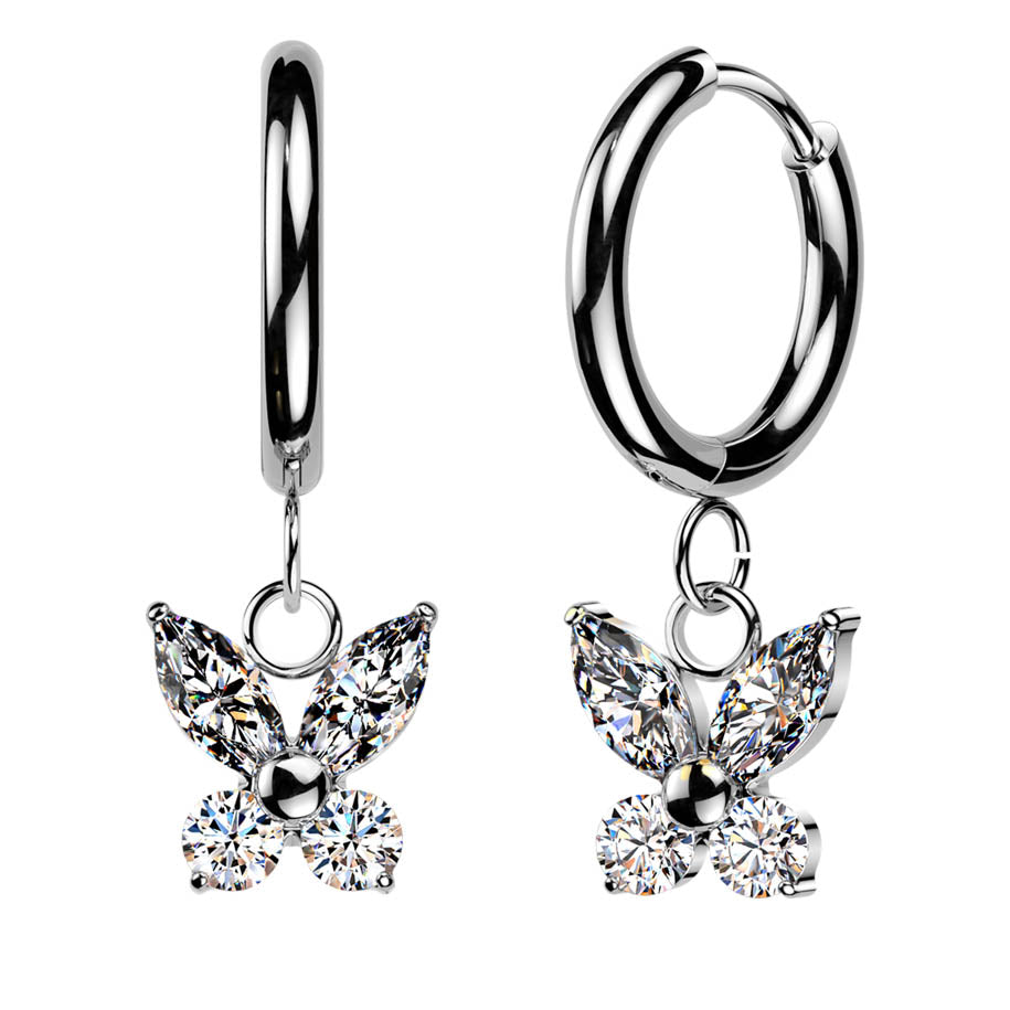 A pair of silver huggie hoop earrings, each adorned with a dangling butterfly charm made of clear marquise and round gemstones, shown against a plain white background.