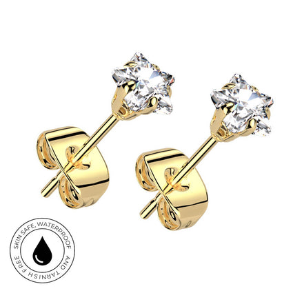 A pair of yellow gold stud earrings with clear faceted gemstones in a prong setting, shown on a white background with a circular 'Skin Safe Waterproof' badge in the lower-left corner.