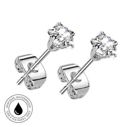 A pair of silver stud earrings with clear gemstones in a prong setting, shown on a white background with a circular 'Skin Safe Waterproof' badge in the lower left corner.