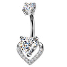 A silver-toned belly button ring featuring a curved barbell with a large heart-shaped clear gemstone at the bottom and a smaller round clear gemstone at the top, set against a plain white background.