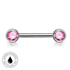 A silver-toned labret piercing barbell with two round pink gemstones, shown on a white background with a circular 'Skin Safe Waterproof' badge in the lower-left corner.