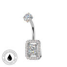 A silver-toned curved barbell belly button ring with a rectangular halo setting and a central princess-cut clear gemstone, shown on a white background with a small circular skin-safe waterproof badge in the lower left.