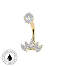 Gold curved barbell navel jewelry with a round clear gemstone top and a cluster of marquise-cut and round clear gemstones below, shown on a white background with a small circular skin-safe waterproof badge in the lower left.