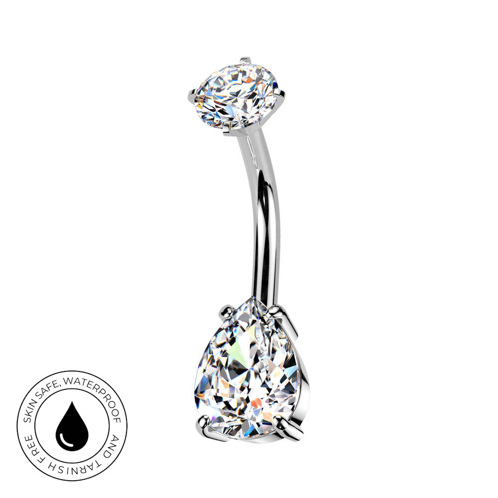 A curved barbell belly button ring with a large pear-cut clear gemstone and a smaller oval-cut clear gemstone, shown on a white background with a circular 'Skin Safe Waterproof' badge in the lower left corner.