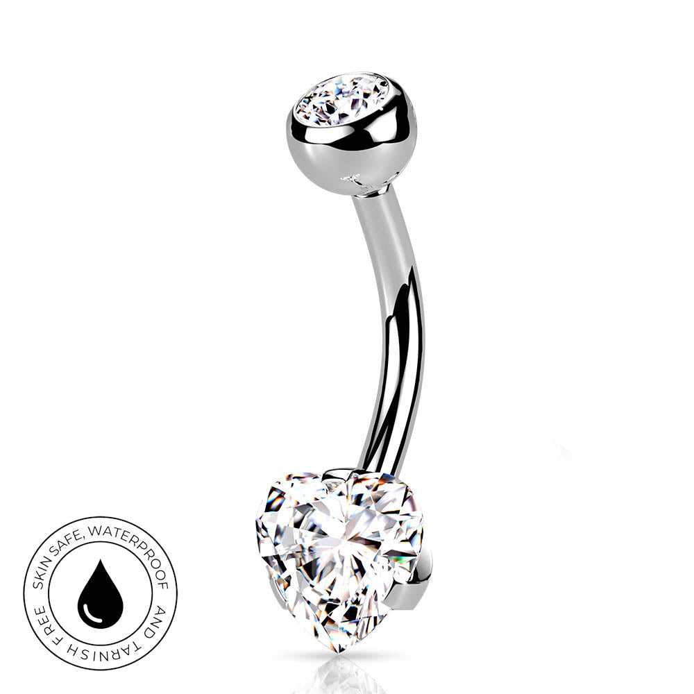 A curved barbell belly button piercing with a heart-shaped clear gemstone at the bottom and a round clear gemstone at the top, shown on a white background with a circular 'Skin Safe Waterproof' badge in the lower left.