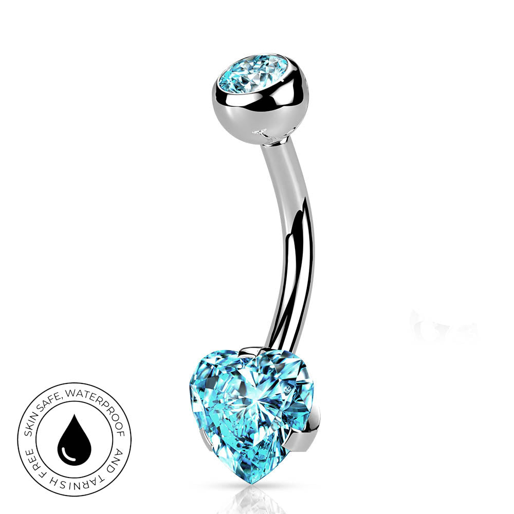A curved barbell belly button ring with a polished silver-tone metal setting, featuring a large faceted light blue heart-shaped crystal on the lower end and a smaller matching light blue oval crystal on the upper end. A circular 'Skin Safe Waterproof' badge is shown in the bottom-left corner on a plain white background.