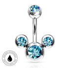 Silver-toned curved barbell navel jewelry with three ball ends, each set with a faceted light blue gemstone, shown on a white background with a small circular 'skin-safe waterproof' badge in the lower left.