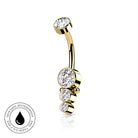 Gold curved barbell navel piercing with three stacked bezel-set clear cubic zirconia stones, shown on a white background with a circular 'Skin Safe Waterproof' badge in the lower-left corner.