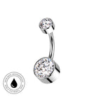 A curved barbell belly button ring with two clear faceted gemstones in polished silver-toned settings, shown on a white background with a circular 'Skin Safe Waterproof' badge in the lower-left corner.