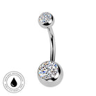 A curved barbell belly button ring with a top and bottom round bezel-set clear crystal, shown on a white background with a small circular 'skin-safe waterproof' badge in the lower left.