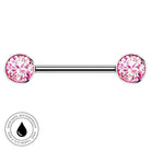 A silver-toned barbell piercing jewelry piece with two round pink gemstones, shown on a plain white background with a small circular 'skin-safe waterproof' badge in the lower left corner.