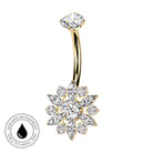 Gold curved navel barbell with a snowflake-shaped crystal cluster pendant, shown on a white background with a circular 'skin-safe waterproof' badge in the lower left.