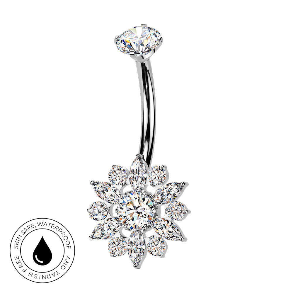 A curved barbell belly button ring with a snowflake-shaped cluster of clear crystals on a white background, featuring a circular 'Skin Safe Waterproof' badge in the bottom-left corner.