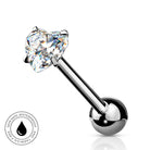 A silver-toned labret piercing barbell with a heart-shaped clear gemstone and a polished ball end, shown on a white background with a small circular 'skin-safe waterproof' badge in the lower left.