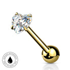 A gold-plated labret piercing barbell with a heart-shaped clear gemstone, shown on a white background with a circular 'SkinSafe Waterproof' badge in the bottom-left corner.