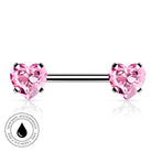 A silver-toned barbell piercing jewelry piece with two heart-shaped pink gemstones, shown on a white background with a circular 'Skin Safe Waterproof' badge in the lower-left corner.