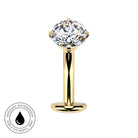 A gold-plated labret piercing stud featuring a large, clear, round-cut gemstone in a four-prong setting. The image is set against a plain white background and includes a circular graphic overlay in the bottom-left corner with a water droplet icon and the text 'SKINSAFE WATERPROOF AND TARNISH FREE'.