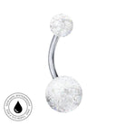 A curved barbell navel piercing jewelry piece with clear, glitter-filled spheres at both ends and a polished silver-tone metal center, shown on a plain white background with a circular 'Skin Safe Waterproof' badge in the lower-left corner.