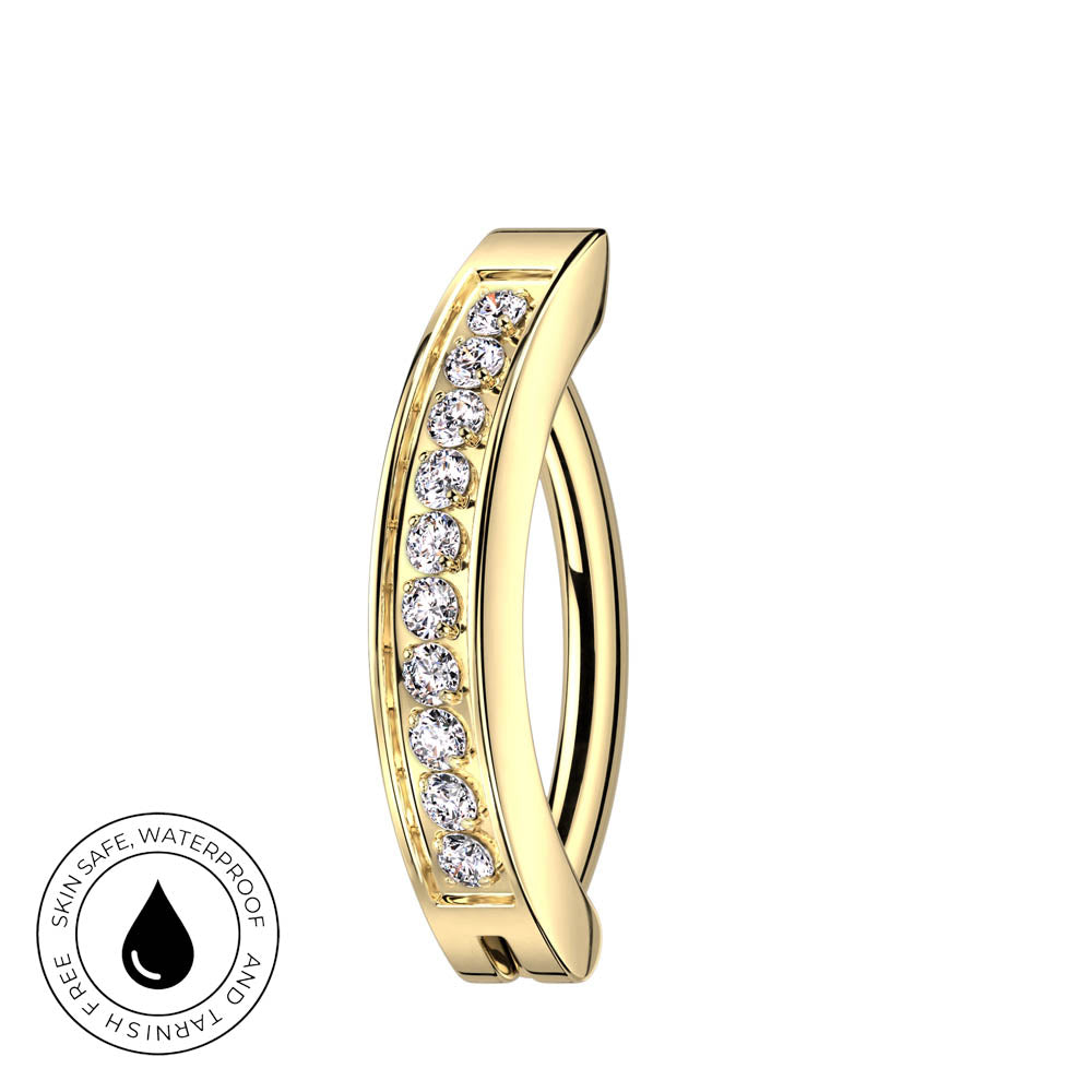 A gold curved hoop ring with a row of clear gemstones on the front, shown on a plain white background with a circular 'skin-safe waterproof' badge in the lower-left corner.