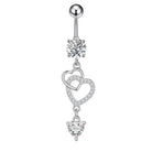A silver-toned belly button ring featuring a round ball stud, a clear faceted gemstone, and two dangling heart charms adorned with small clear crystals, set against a plain white background.