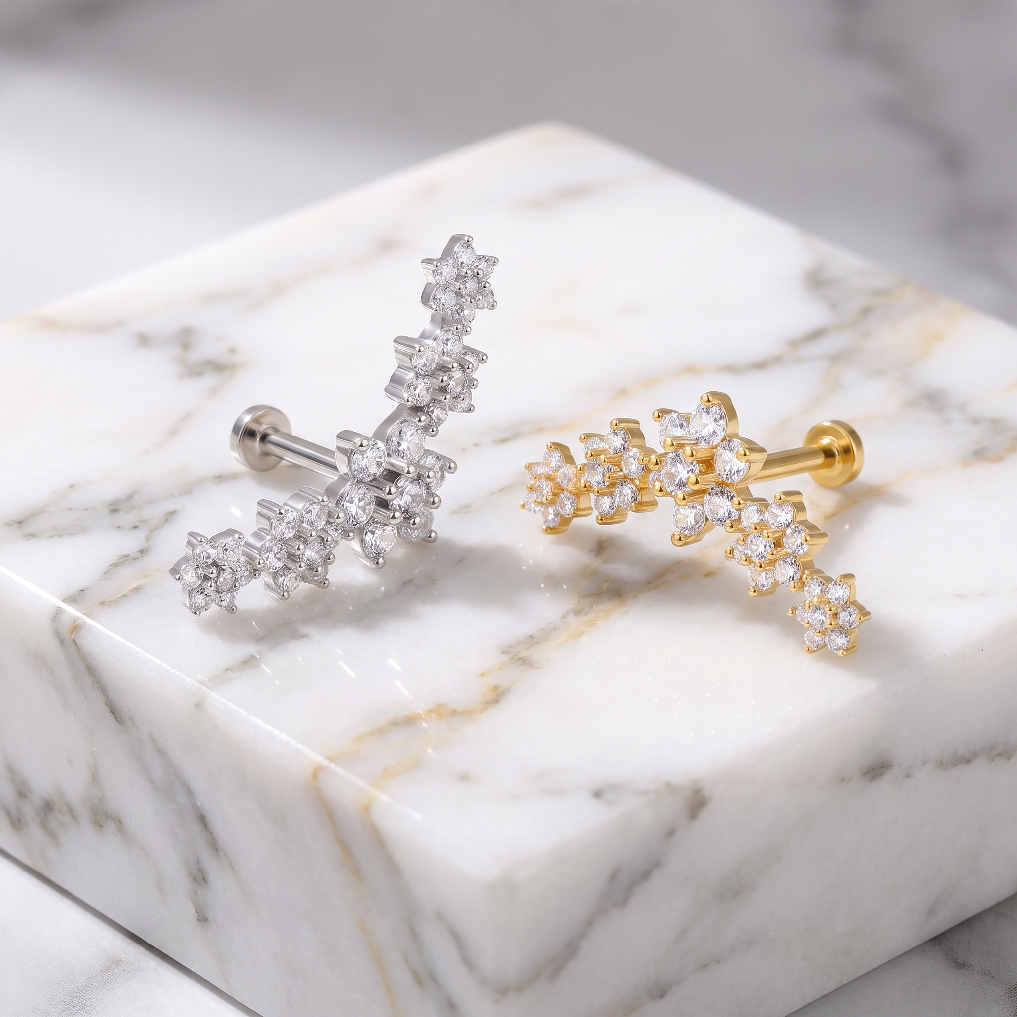 GOLD AND SILVER FLOWER CARTILAGE STUDS ON MARBLE BLOCK